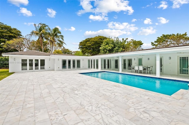 outdoor pool featuring french doors and a patio