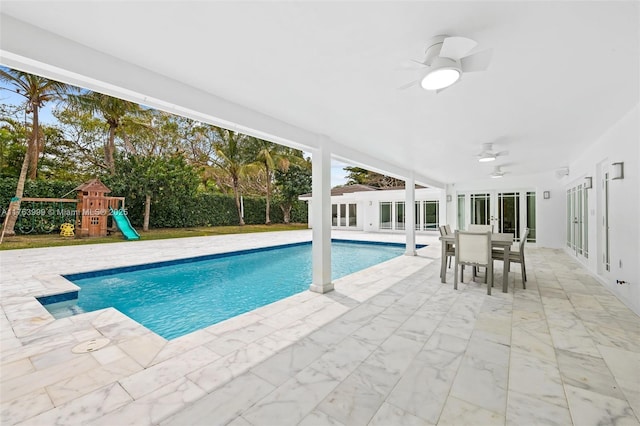 view of pool with a patio, a playground, french doors, a fenced in pool, and ceiling fan