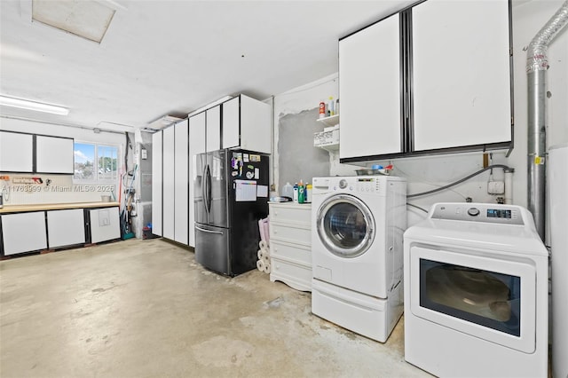 clothes washing area with cabinet space and washer and dryer