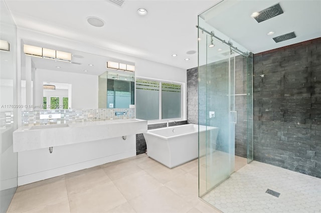 full bathroom featuring a soaking tub, double vanity, tile patterned flooring, a shower stall, and tasteful backsplash