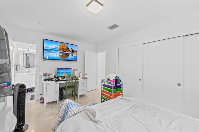 bedroom with a closet, visible vents, and light tile patterned floors