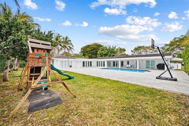 exterior space featuring a playground, a lawn, french doors, a patio area, and an outdoor pool