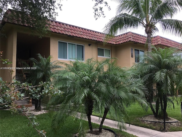 exterior space featuring a tile roof and stucco siding