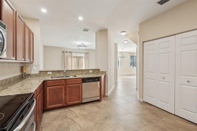 kitchen featuring a healthy amount of sunlight, visible vents, a sink, appliances with stainless steel finishes, and brown cabinets