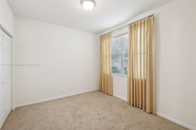 carpeted spare room featuring baseboards