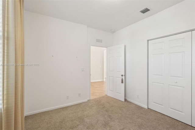 unfurnished bedroom with baseboards, visible vents, and carpet floors