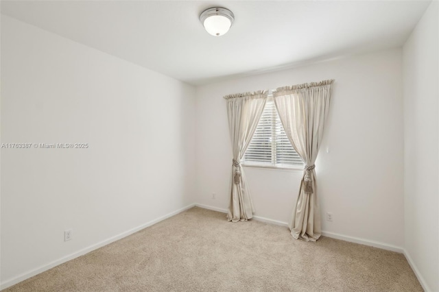 unfurnished room with light colored carpet and baseboards