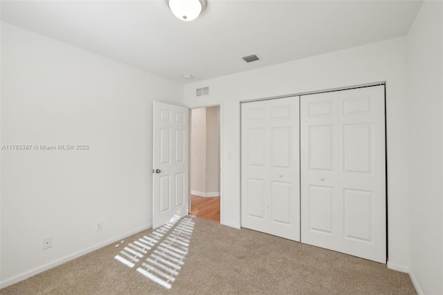 unfurnished bedroom featuring visible vents, carpet, and a closet