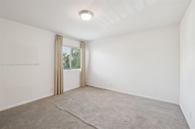 spare room with baseboards and carpet floors