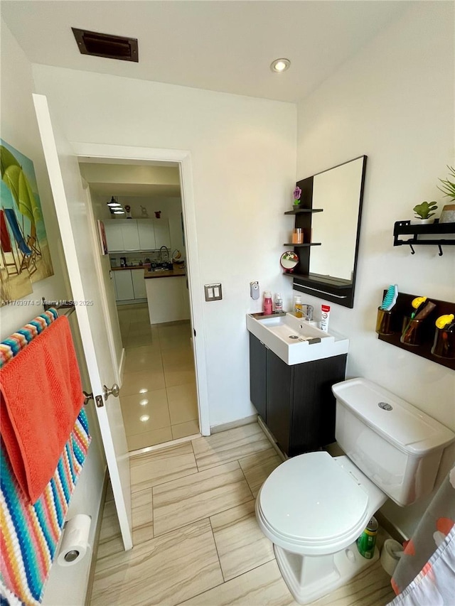 bathroom with vanity, toilet, and visible vents