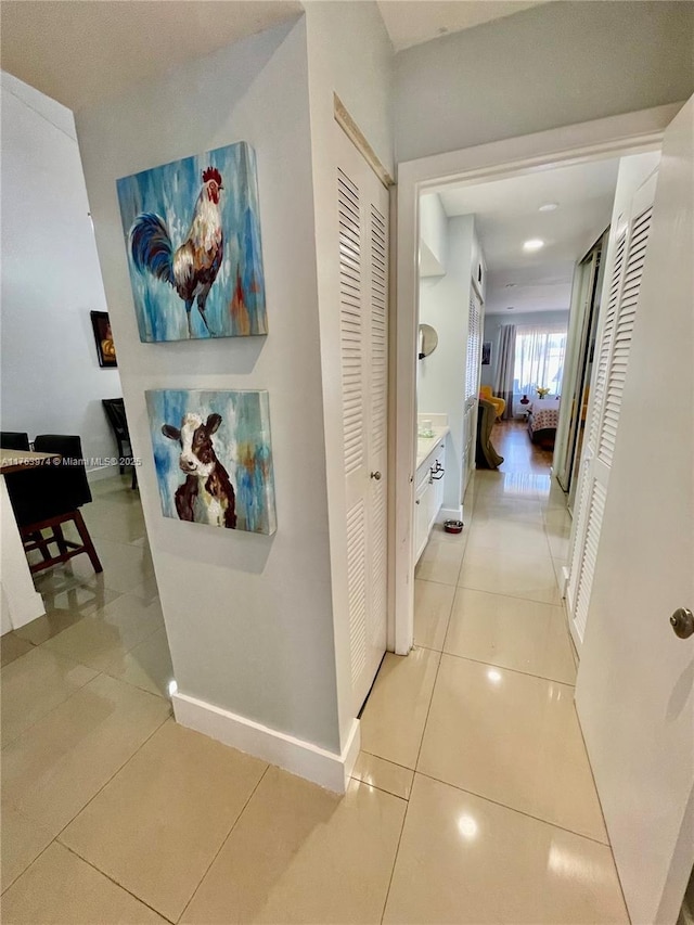 hall with light tile patterned floors and baseboards