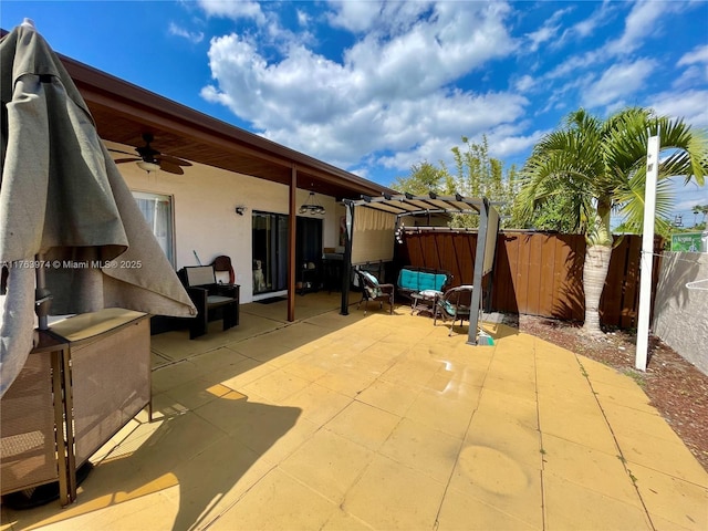 view of patio with fence and ceiling fan