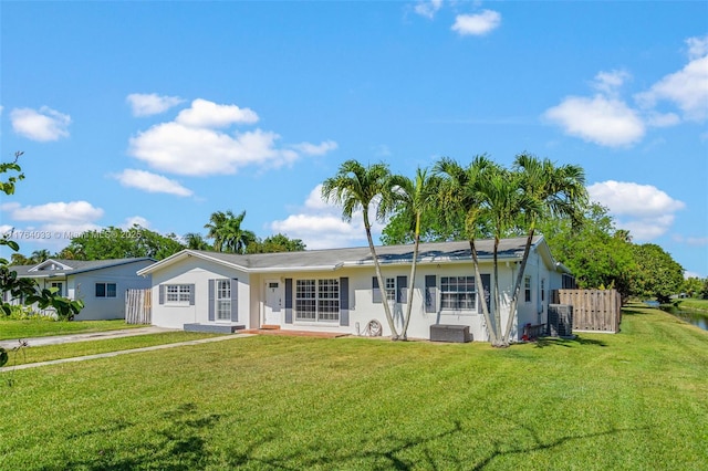 ranch-style house featuring stucco siding, central AC unit, a front yard, and fence