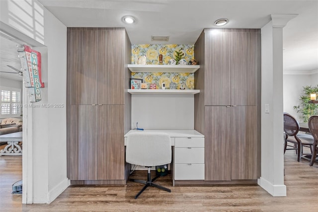 home office with visible vents, built in study area, light wood-type flooring, and baseboards