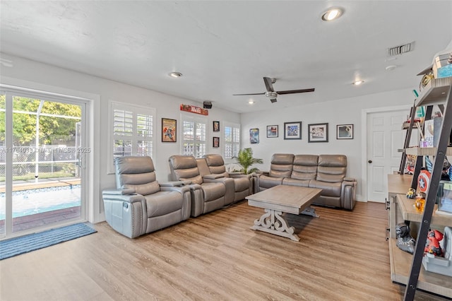 living area with light wood finished floors, visible vents, and ceiling fan