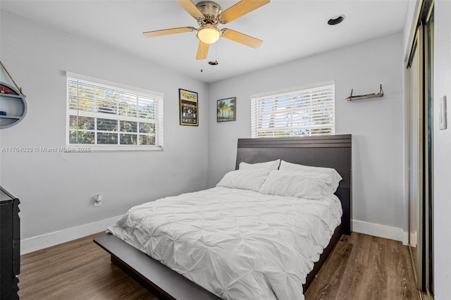 bedroom featuring ceiling fan, baseboards, and wood finished floors