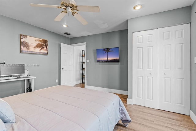 bedroom featuring visible vents, baseboards, ceiling fan, a closet, and light wood-type flooring