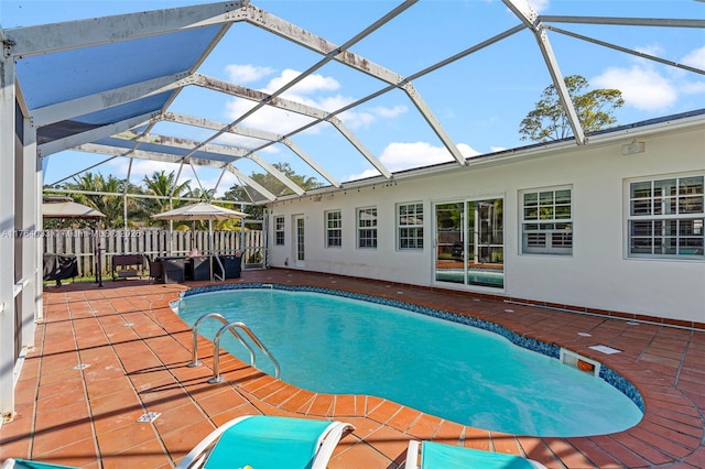 view of swimming pool with a lanai, fence, a patio area, and a fenced in pool