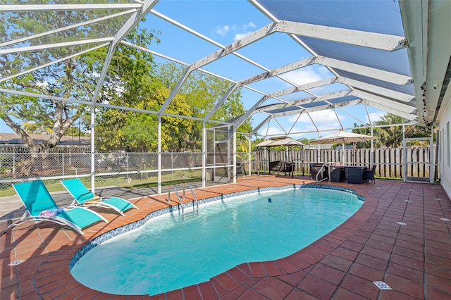 view of pool with a fenced in pool, a patio, glass enclosure, and a fenced backyard