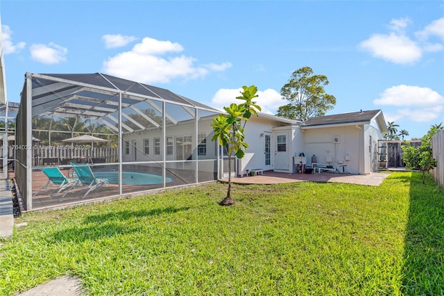 back of house with stucco siding, a fenced backyard, a yard, a lanai, and a patio area