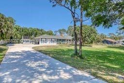 ranch-style house with driveway and a front yard