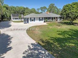 view of front of home with curved driveway and a front yard