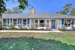 single story home with a chimney and a front yard