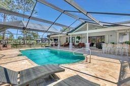 outdoor pool featuring a patio area and glass enclosure