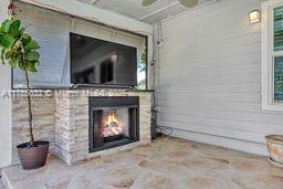 view of patio with a fireplace and ceiling fan