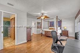 bedroom featuring wood finished floors, visible vents, and baseboards