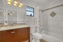 bathroom with a chandelier, toilet, vanity, and shower / bath combo