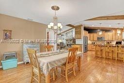 dining area with baseboards, an inviting chandelier, and wood finished floors