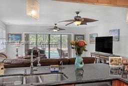 kitchen with dark countertops, a ceiling fan, and a sink