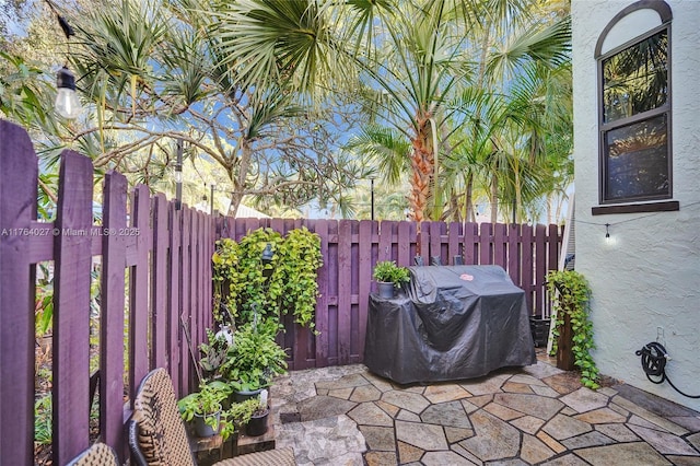 view of patio / terrace with a grill and fence