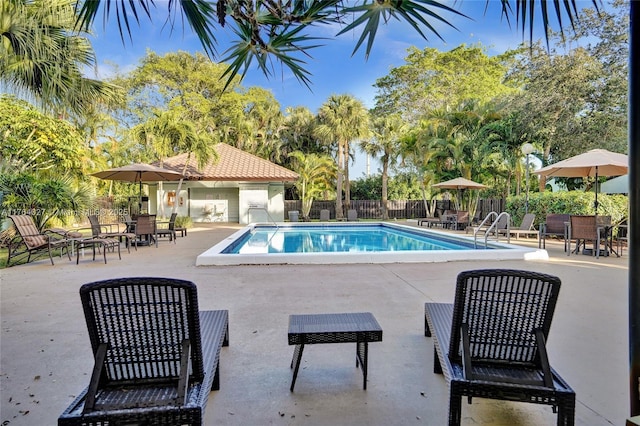 pool featuring a patio area and fence