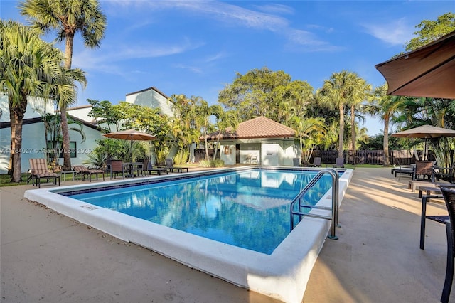 pool with a patio and fence