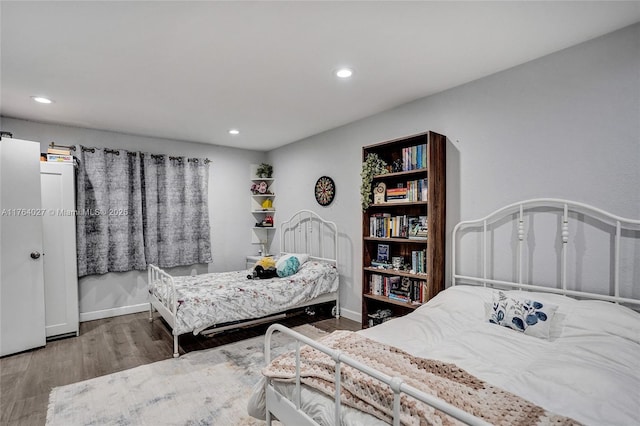 bedroom with recessed lighting, baseboards, and wood finished floors