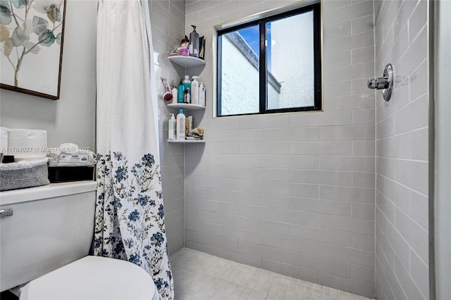 bathroom with tiled shower and toilet