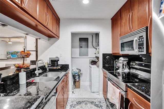 kitchen with dark stone countertops, brown cabinetry, a sink, stainless steel appliances, and marble finish floor