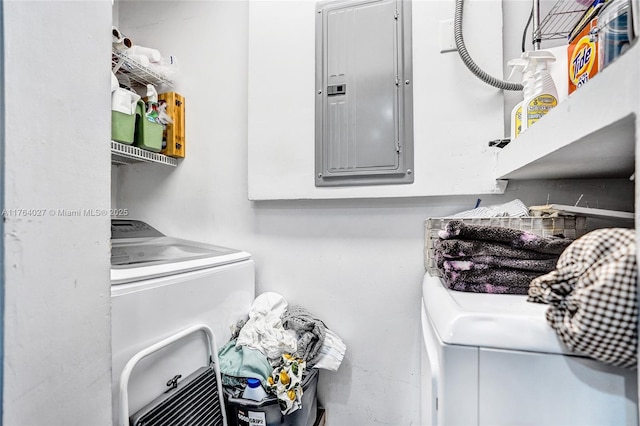 clothes washing area featuring electric panel, separate washer and dryer, and laundry area