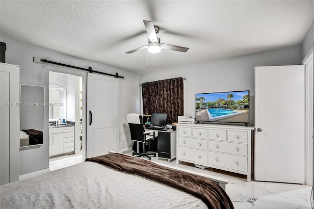 bedroom featuring connected bathroom, ceiling fan, a barn door, marble finish floor, and a textured ceiling