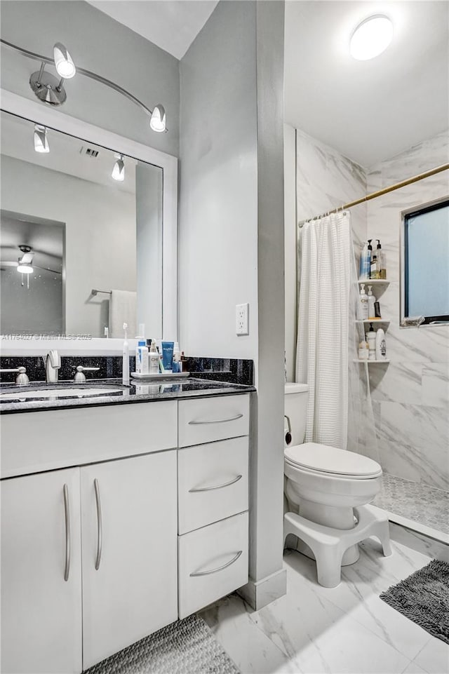 bathroom with curtained shower, toilet, vanity, and marble finish floor