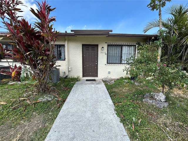 doorway to property featuring stucco siding