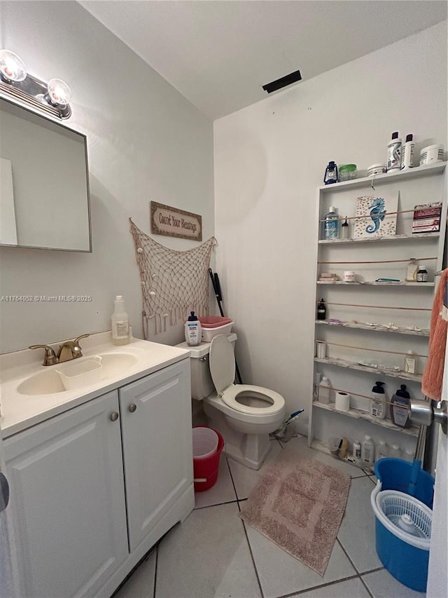 bathroom featuring toilet, vanity, and tile patterned flooring