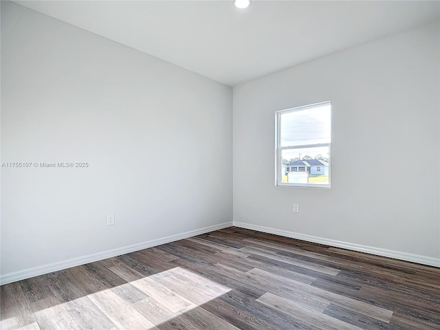 empty room with baseboards and wood finished floors