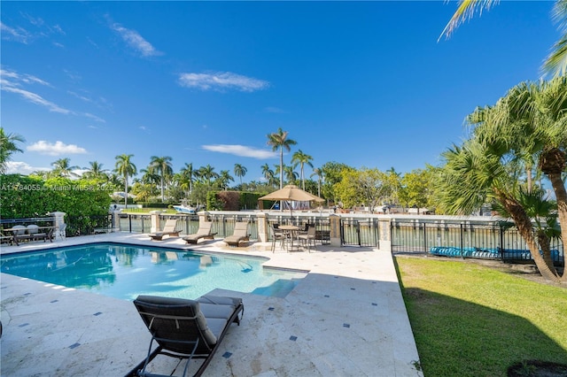 view of pool featuring a fenced in pool, fence, a lawn, and a patio area