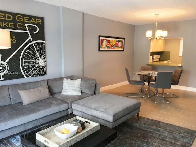 tiled living area featuring a notable chandelier and baseboards