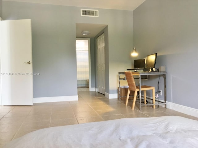 bedroom with tile patterned floors, visible vents, baseboards, and connected bathroom