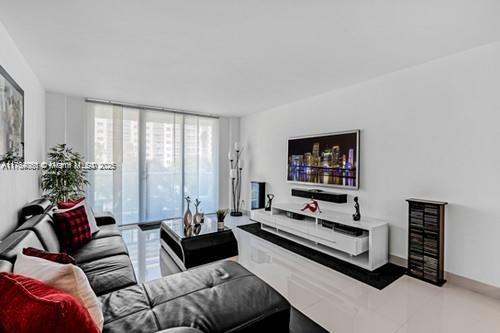 tiled living area with a wall of windows and baseboards