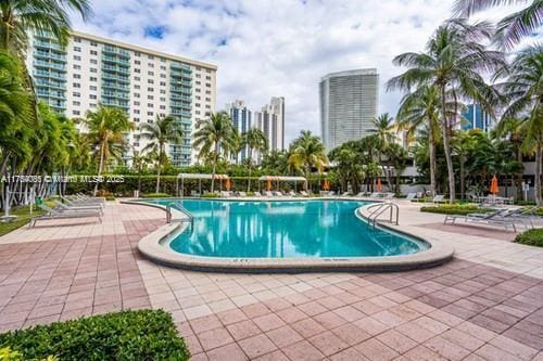 pool with a patio area and a city view